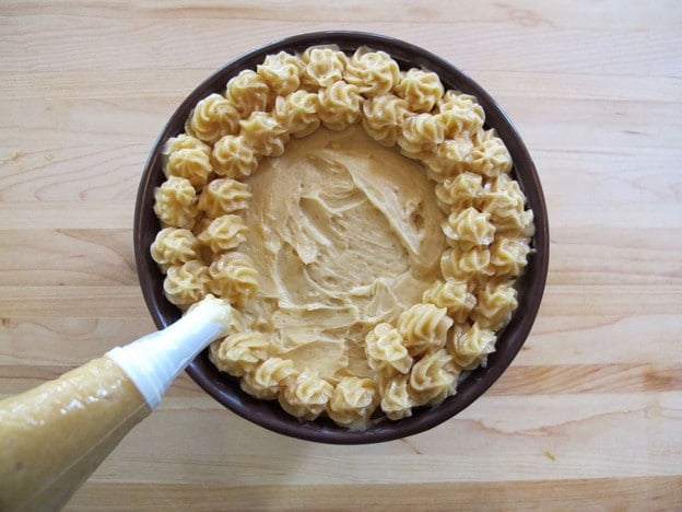 Piping stars of butter in circles on the top of the bowl of butter.