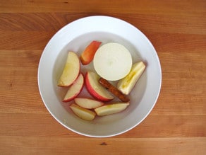 Sliced apples in a small bowl of warm water.