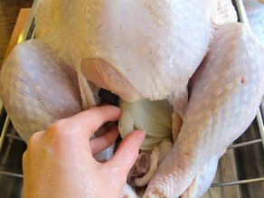 Stuffing aromatics in turkey cavity.