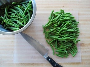 Cut green beans into 2-inch pieces on a cutting board.
