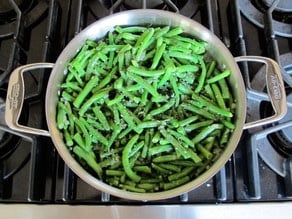 Cut green beans added to onions in skillet.