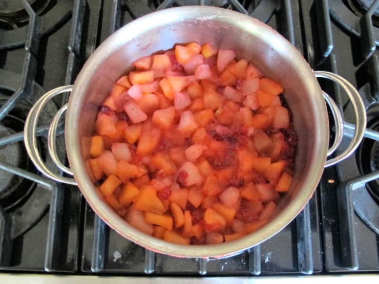 Cranberries and apples cooked down in a pot.