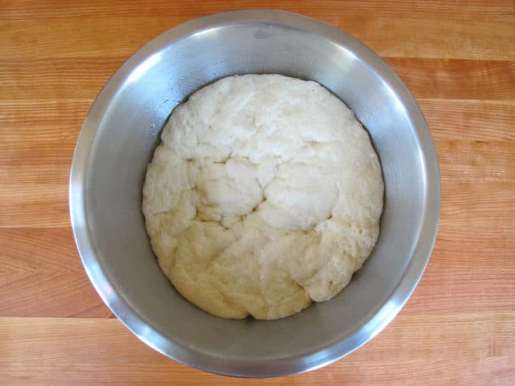 Proofed challah dough in a bowl.
