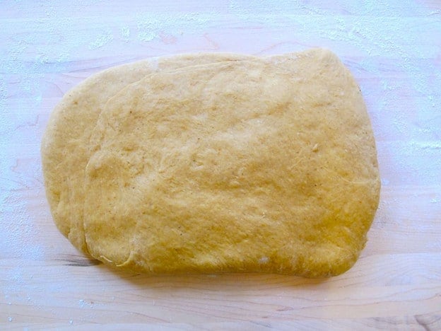 Two thirds of challah dough flattened into a rectangle.
