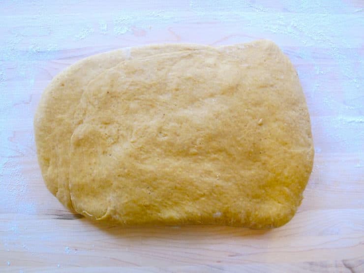 Two thirds of challah dough flattened into a rectangle.