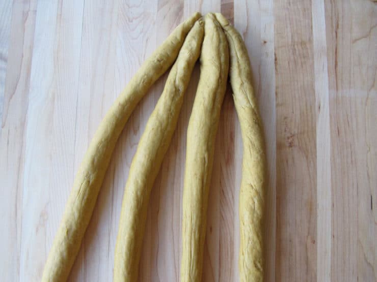 Pinch the four dough strands together on one end.