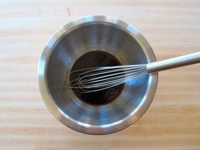 Soy sauce marinade whisked in a small bowl.