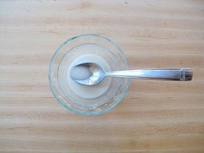 Mixing a cornstarch slurry in a small bowl.