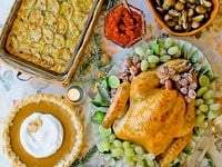 Thanksgiving Potluck spread with various foods, highlighted by a turkey centerpiece
