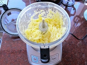 Grated potatoes in a food processor.