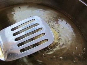 Frying latkes in hot oil.