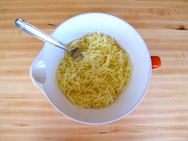 Combining potatoes and onions in a bowl.