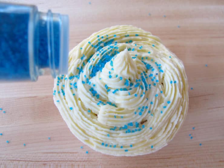 Sprinkle blue decorating sugar on top of frosted cupcakes.