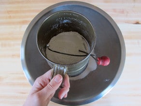 Sifting flour into a large mixing bowl.
