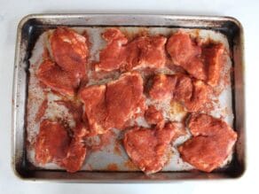 Tray of seasoned smoked paprika chicken, uncooked.