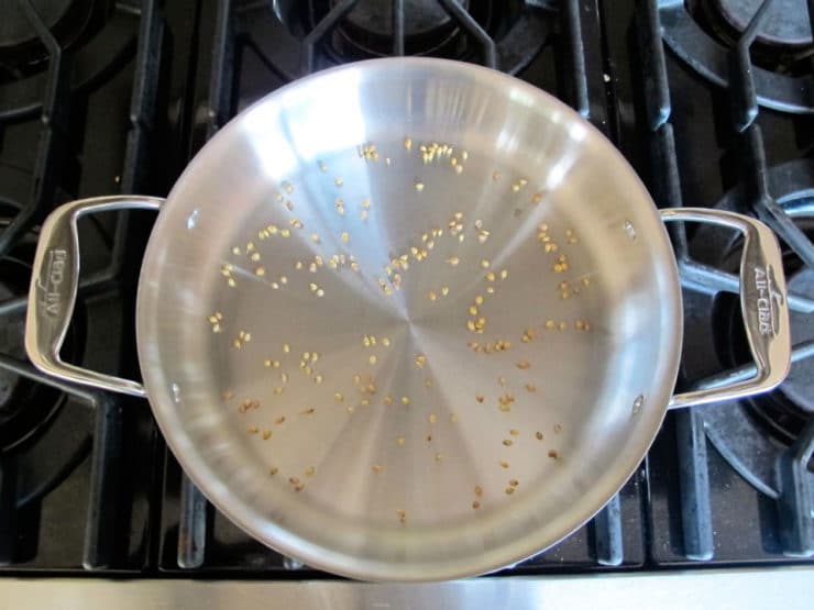 Toasting whole coriander in a dry skillet.