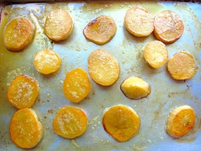 Baking potato slices on a baking sheet.