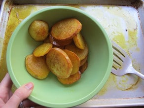 Sliced, oven friend potatoes resting in a bowl.