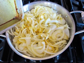 Sliced onions in a large saute pan.
