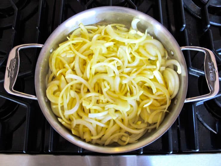 Sliced onions in a large saute pan.