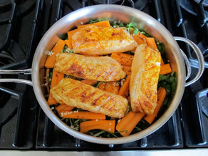 Seared fish fillets on carrots in a saucepan.