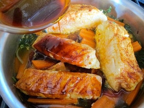 Pour seasoned oil over fish fillets.
