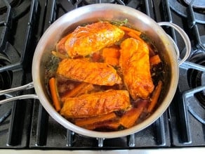 Fish fillets over carrots with liquid reduced down.