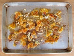 Extra small pieces of cauliflower added to baking sheet.