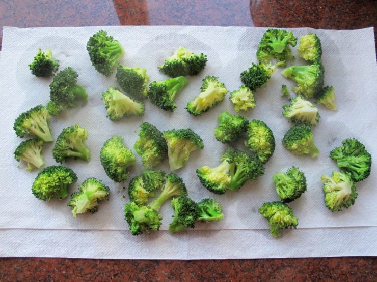 Steamed broccoli draining on paper towels.
