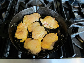 Frying chicken thighs in a skillet.