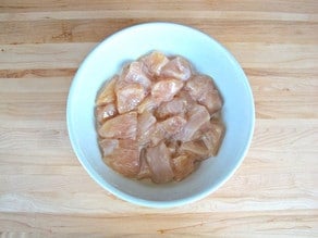 Chicken pieces marinating in egg whites.