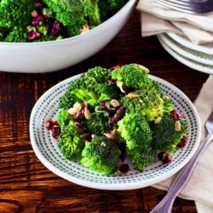 A colorful broccoli craisin salad made with broccoli florets, craisins, and a creamy dressing, served in a white bowl