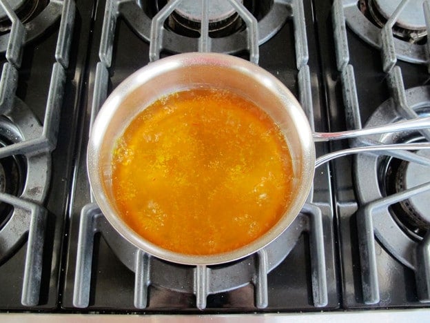 Chicken broth and saffron in a saucepan.