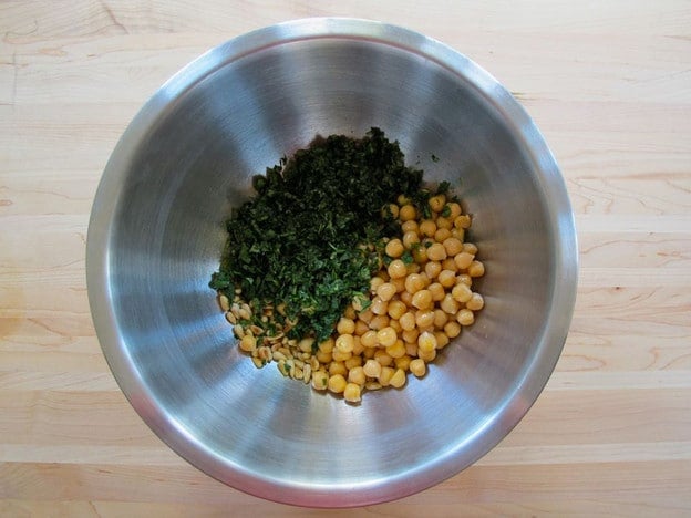 Garbanzo beans and cilantro in a mixing bowl.