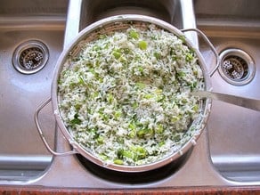 Draining cooked rice in a colander.
