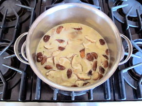 Coconut milk added to simmering soup.