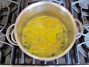 Chicken and lemongrass simmering in a pot of stock.