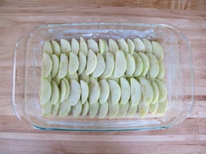 Sliced apples in a baking dish.