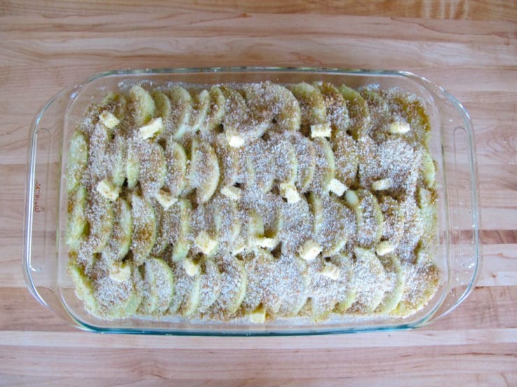 Breadcrumbs sprinkled over apples in baking dish.