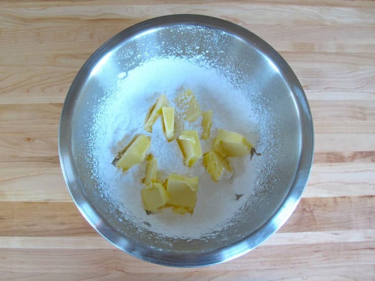 Cubed butter added to powdered sugar.