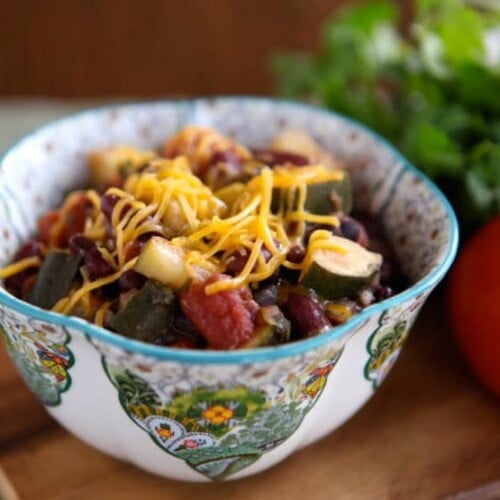 A colorful garden vegetable medley topped with melted cheese in a bowl