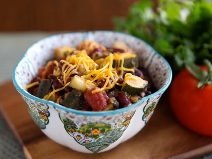 A colorful garden vegetable medley topped with melted cheese in a bowl