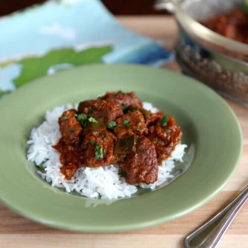 Hungarian Beef Goulash on a sage green plate with fork on the right side.