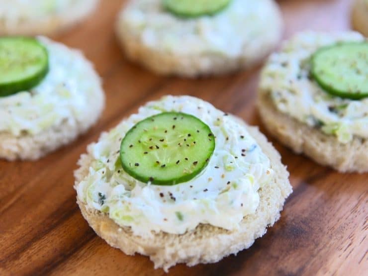 Cucumber rye open faced finger sandwich, crustless, with pepper on a wooden background. 