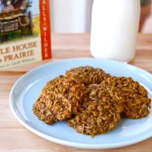 Plate of 4 molasses cookies with Little House on the Prairie book and bottle of milk in background.