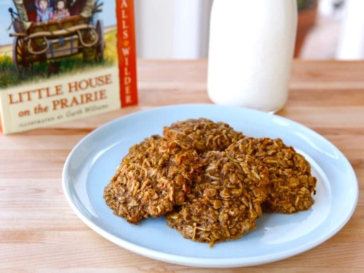 Plate of 4 molasses cookies with Little House on the Prairie book and bottle of milk in background. 