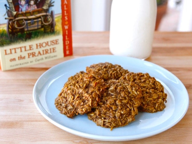Plate of 4 molasses cookies with Little House on the Prairie book and bottle of milk in background.