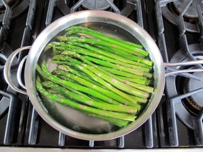 Asparagus in boiling water in a saucepan.
