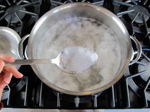 Skimming foam from cooking beans.
