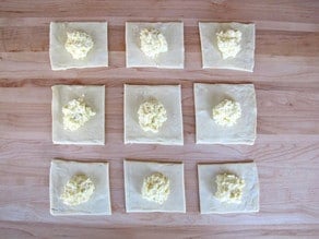Cheese filling placed in center of puff pastry squares.